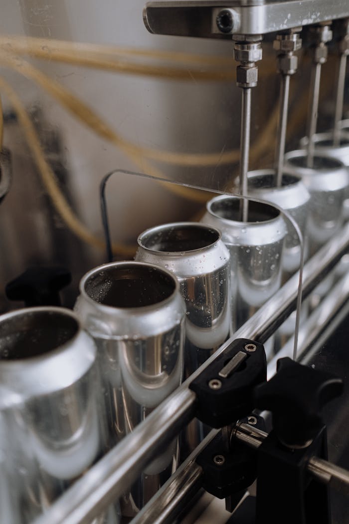creative Close-up view of an automated can filling line in a brewery showcasing aluminum cans and machinery.